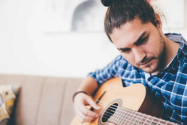 Man playing an acoustic guitar, photographed by GCShutter