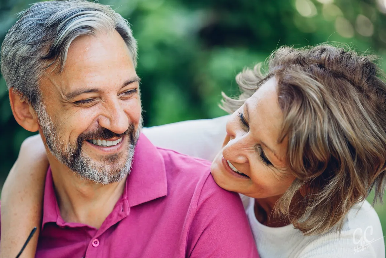 Smiling couple embracing outdoors, photographed by GCShutter