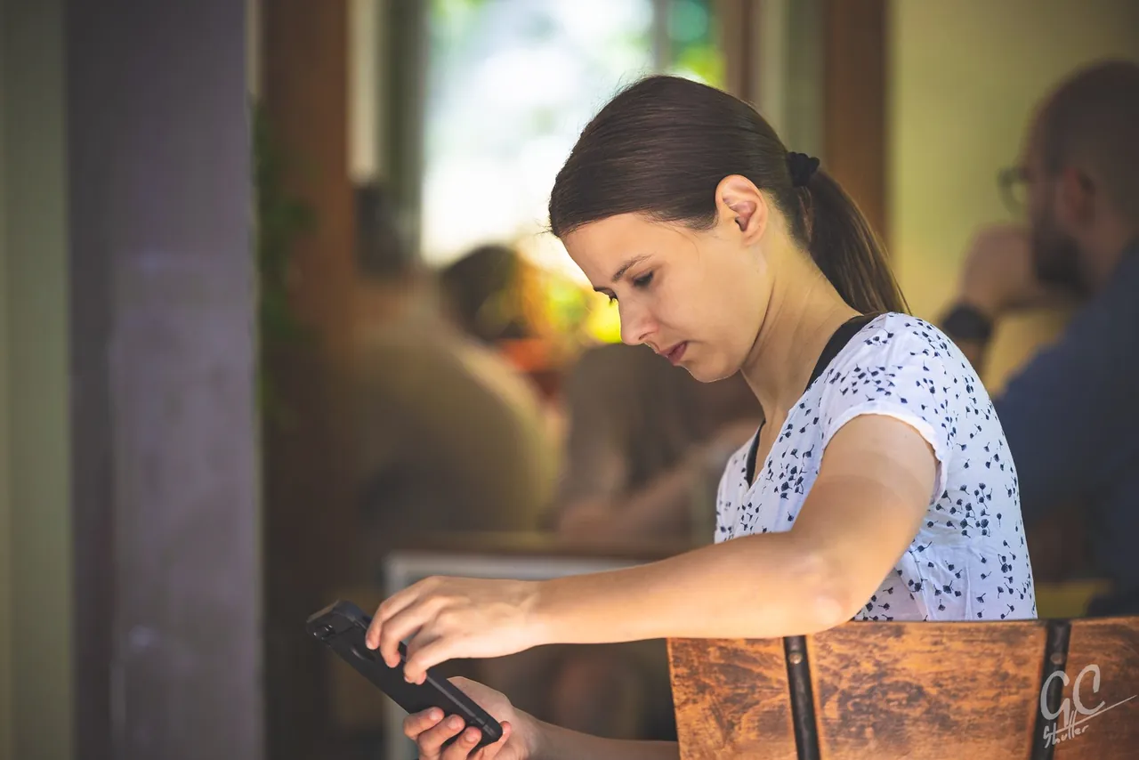 Young woman working on a laptop in a cafe, photographed by GCShutter