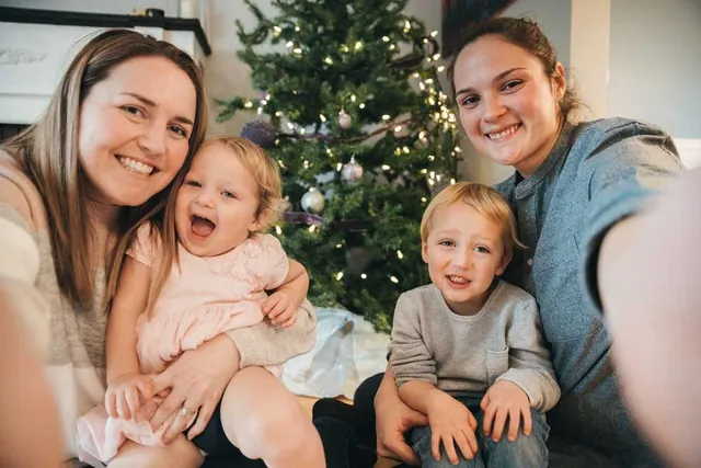Family together by a Christmas tree, photographed by GCShutter